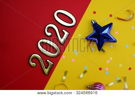 On A Red And Yellow Background Are Laid Out The Numbers 2020 With Confetti And Christmas Toys