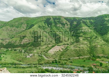 Panoramic View Of Vardzia Cave Monastery Town. View From The Monastery To The River Valley And Green