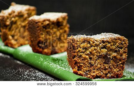 Homemade Tart Slices On A Black Background With Chocolate, Italian Amaretti Cookies, Nuts And Yogurt