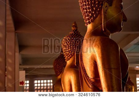 Indoor A Lot Of Buddha Statue In The Row, Are Sitting In The Dark Place.