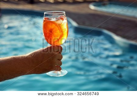 Man With Glass Of Fresh Summer Cocktail Near Swimming Pool Outdoors, Closeup. Space For Text