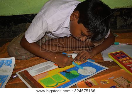 Jhargram, West Bengal, India - September 25, 2019: A Poor Indian Primary School Boy Drawing In A Sit