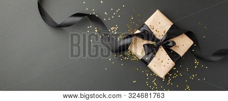 Gift Or Present Box And Gold Stars Confetti On Black Table Top View. Flat Lay Composition For Birthd