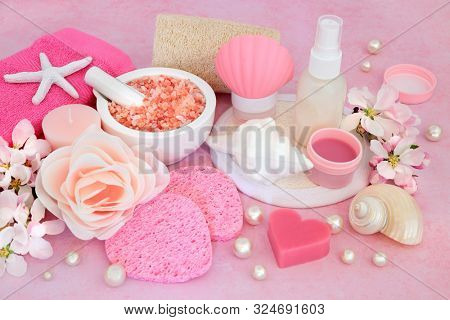 Skincare beauty treatment with spa, ex foliation and cleansing products with apple blossom flowers on pink background.