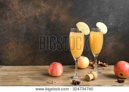 Apple Mimosa Cocktail In Tall Glasses And Organic Apples On Dark, Copy Space. Seasonal Fall Drinks -
