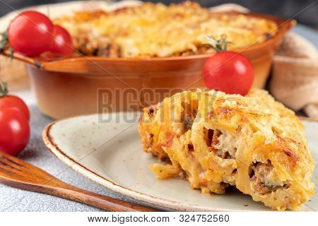 Golden Cannelloni With Meat, Tomatoes, Cheese Sauce And Pasta In Alternating Layers On A Rustic Plat