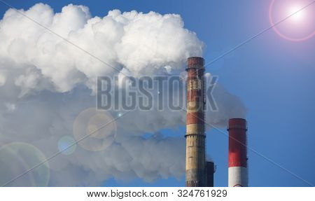 White Smoke Comes From Pipes Against Blue Sky. Problem Harmful Emissions And Air Pollution Of Centra