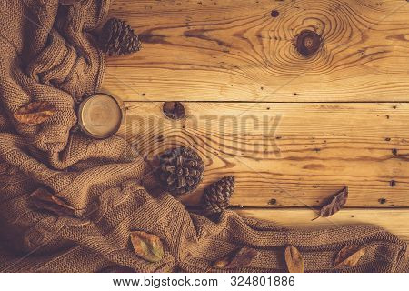 Autumn Background. A Cup Of Hot Coffee, Knitted Scarf And Pinecones On Wooden Table. Autumn Coffee. 