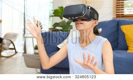 Young Beautiful Asian Woman Exciting In Vr Headset Looking Up And Trying To Touch Objects In Virtual