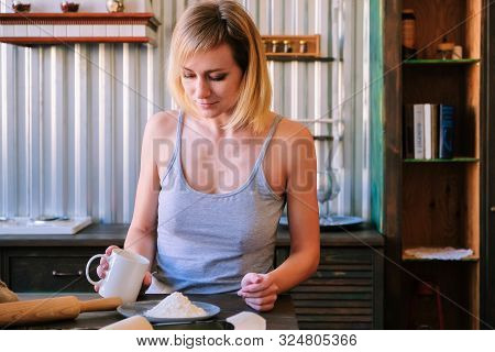 A Beautiful Freckled Blonde Girl In Pajamas Is Standing Near The Kitchen Table, Drinking Fock, Tea A