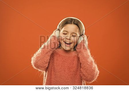 Enjoy Sound. Girl Cute Little Child Wear Headphones Listen Music. Kid Listen Music Orange Background