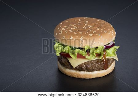Hamburger With A Double Serving Of Meat, Tomatoes, Salad, Onions On A Wooden Board In A Restaurant.c