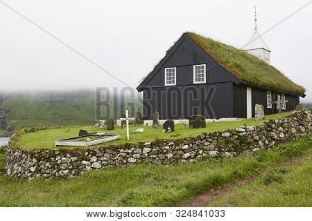 Traditional Turf Church In Faroe Islands On Foggy Day. Kaldbak