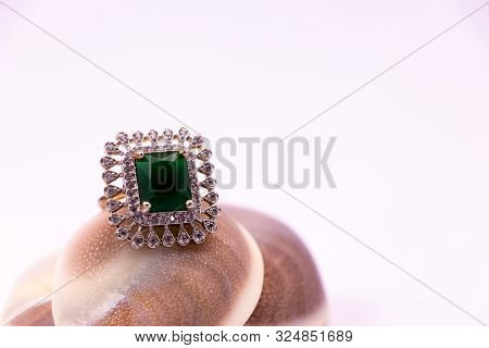 Anniversary Gift Concept. Close View Of Emerald Ring On Seashell On White Background