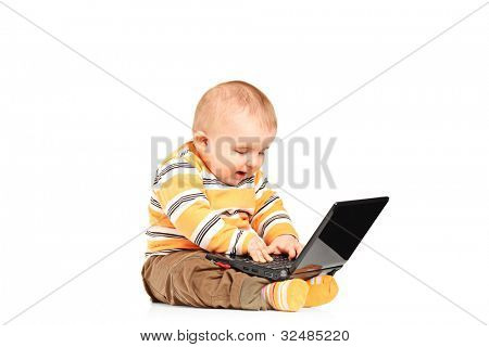 흰 배경에 고립 된 노트북에서 일 하는 아기의 스튜디오 샷