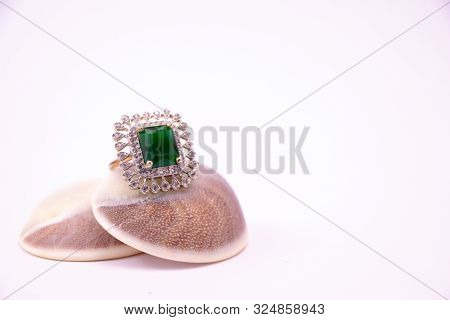 Stone Ring Concept. Close View Of Emarald Ring On Seashell On White Background