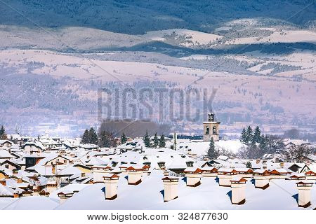 Bansko, Bulgaria Aerial Town Winter View With Houses Snow Roofs And St. Trinity Church Tower, Panora