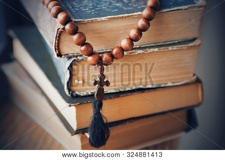 The Sacred Rosary, Made Of Mahogany, Lies On A Pile Of Old Battered Books In Which Religious Precept