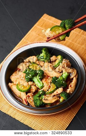 Hunan Chicken In Black Bowl At Dark Slate Background. Hunan Chicken Is Chinese Or Indo-chinese Cuisi