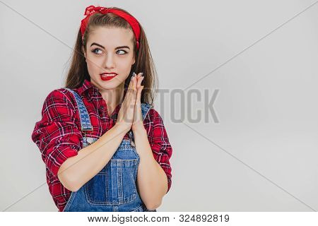 Beautiful Young Girl In Red Standing, Rubbing Her Hands, Thinkinh Up Something Prohibited, Looking T