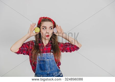 Funny Lovely Girl Is Playing Around, Holding Two Sweet Macaroons Near Ears, Looking Like Cheburashka