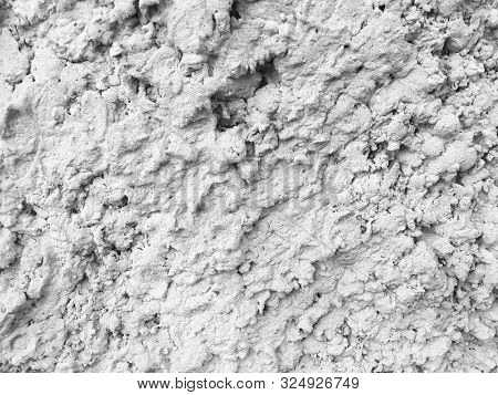 Uneven Concrete Wall Covered With White Paint.