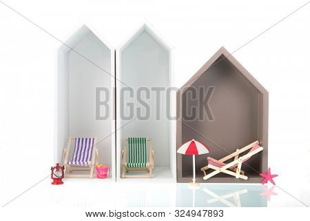 Modern beach houses with deck chairs isolated over white background
