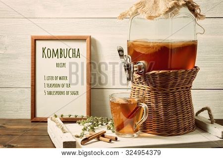 Fresh Homemade Kombucha Fermented Tea Drink In A Jar With Faucet And In A Cup On A White Tray, The R