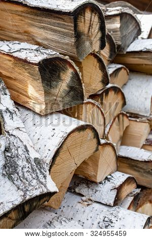 Stack Of Dried Firewood From Birch Wood. Harvesting Wood For The Winter. Firewood Background.