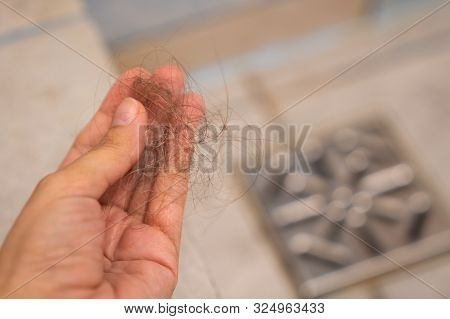 Woman Hand Is Holding Shred Of Hair From A Clogged Shower Drain