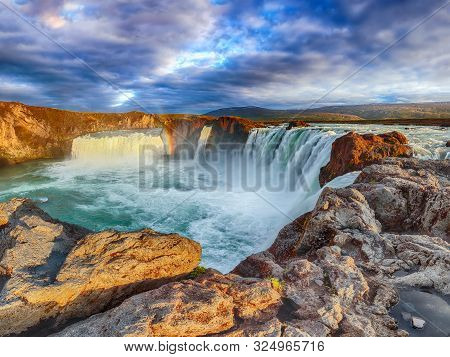 Breathtaking Sunset Landscape Scene Of Powerful Godafoss Waterfall. Dramatic Sky Over Godafoss. Loca