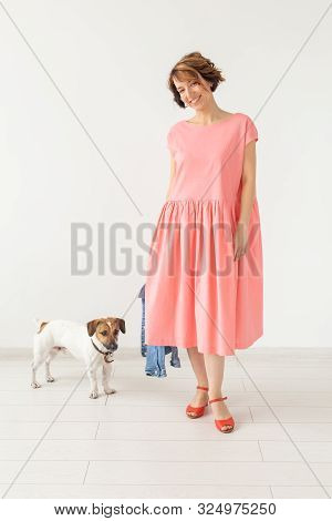 Pet And People Concept - Young Woman In Pink Dress With Jack Russell Over The White Background