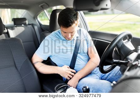transport, vehicle and safe driving concept - man or car driver fastening safety seat belt in summer