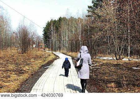 A Woman With A Child Walking In The Park