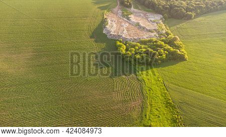 Aerial Shot Of Big Rubbish Pile Lying Among Field In Countryside. Flying Over Garbage Truck Dumping 