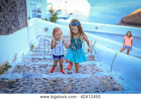 Due moda carini piccolo ragazze-sorelle camminare all'aperto nella città vecchia di Santorini