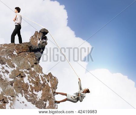 Imagem de busionessman e empresária puxando a corda no topo da montanha