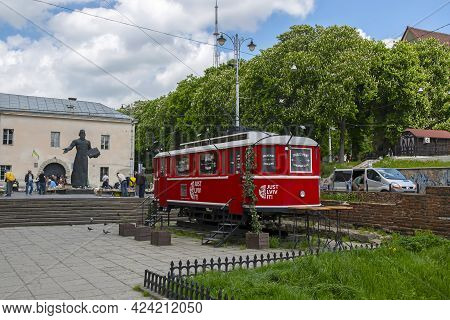 Lviv, Ukraine - May 17, 2021: City Landscape - Tourist Retro Tram And A Monument To The First Printe