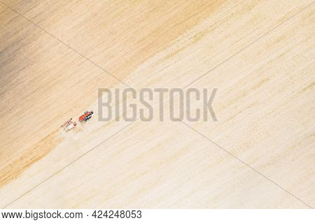 Aerial View. Tractor With Seed Drill Machine Sowing The Seeds For Crops In Spring Season. Beginning 