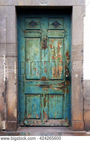 Old weathered timeworn shabby door in Funchal, Madeira island.                         