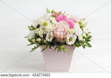 Bouquet Of Different Flowers In A Pink Pot On White Wooden Table.