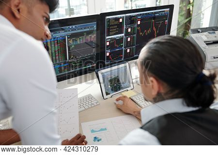Traders Discusing Charts And Digrams And Analyzing Stock Market Data Before Buying And Selling Share