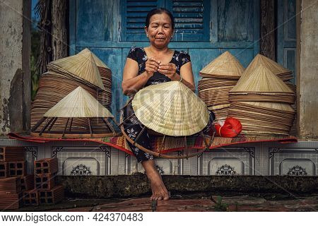 Vietnamese Old Woman Craftsman Making The Traditional Vietnam Hat In The Old Traditional House In Ap