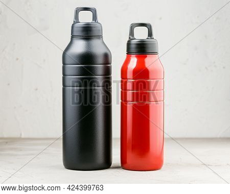 Black And Red Reusable Thermo Water Bottles Of Different Sizes Over Grey Background, Zero Waste, Ref