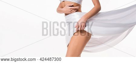 Partial View Of Silk Cloth Covering Hips Of Young Woman Touching Herself With Hands Isolated On Whit