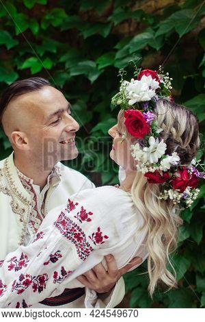 Young People Are Posing In Traditional Folk Costumes. Cossacks Man And Woman In Wreaths And Embroide