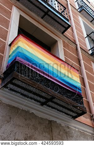 Low Angle View Of Balcony With Rainbow Flag In Chueca Neighbourhood In Madrid