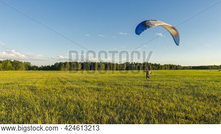 Powered Paraglider Pilot Taking Off With A Back-mounted Lightweight Motor Vehicle (a Paramotor) On A