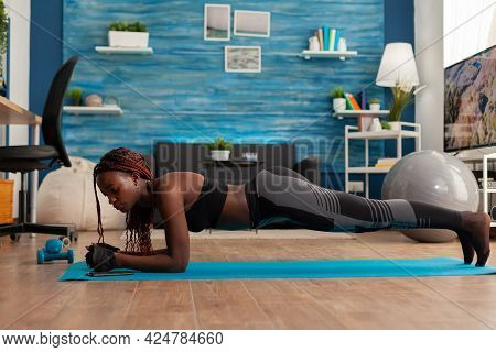 Afro Woman Keeping Plank Position On Yoga Mat On Living Room Floor Training Abddominal Core Stabilit