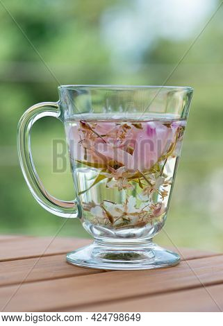 Herbal Rugosa Rose (rosa Rugosa, Japanese Rose) Tea In The Glass Cup On Wooden Table.